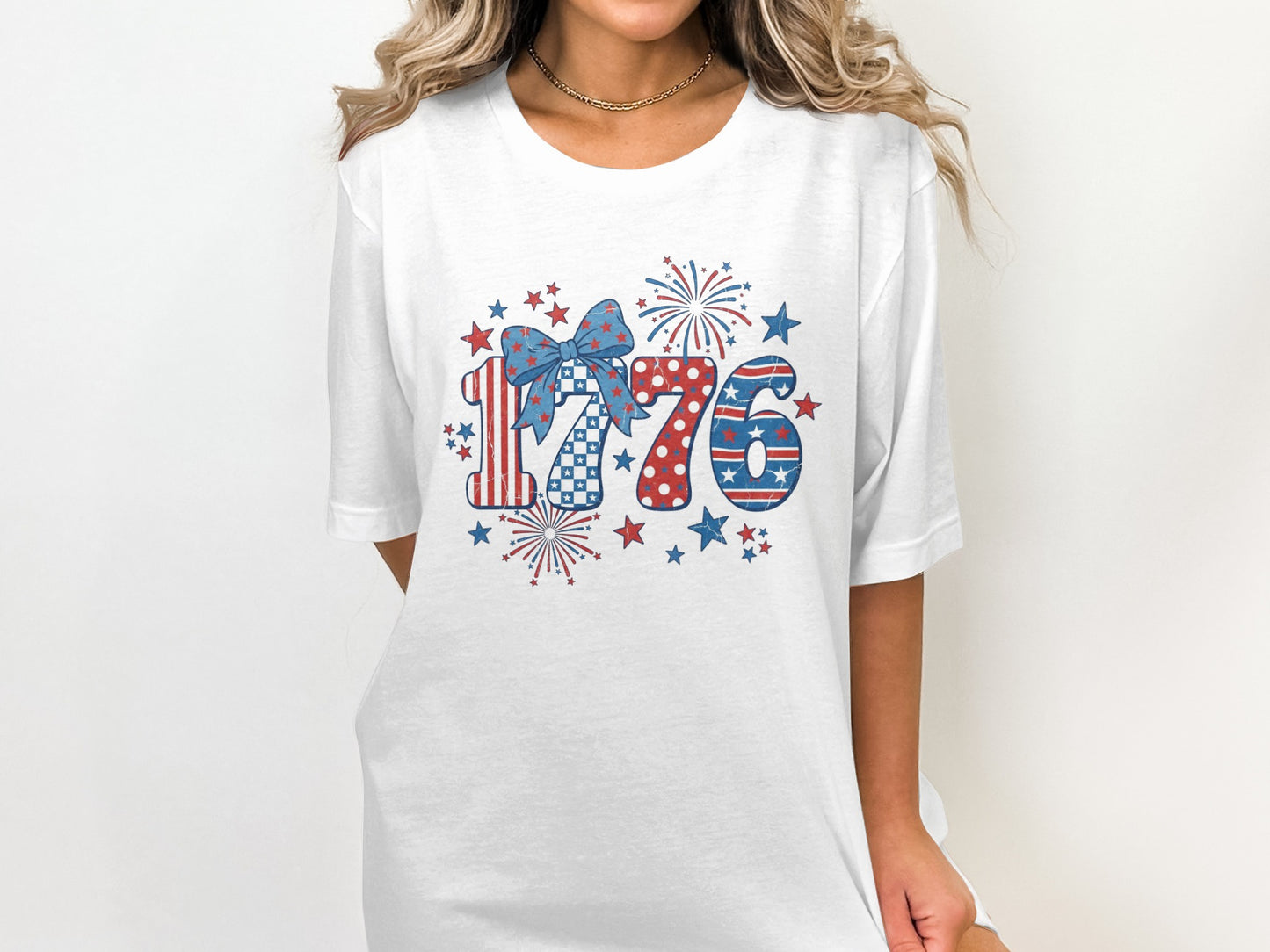 White t-shirt with "1776" in patriotic colors and fireworks motif.
