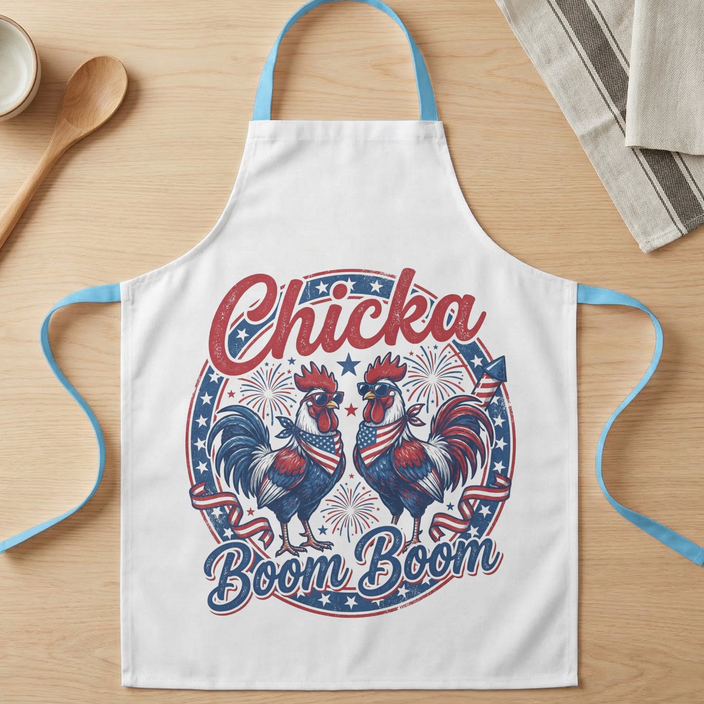 White apron with roosters wearing sunglasses and bandanas, text "Chicka Boom Boom".