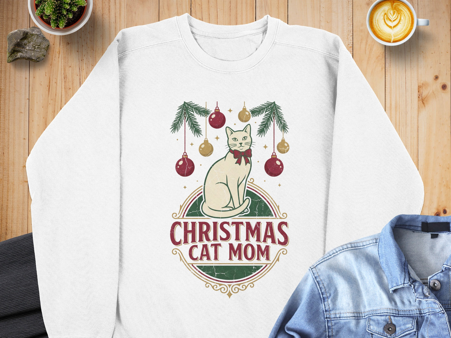 White sweatshirt with a Christmas cat mom graphic featuring a cat and ornaments.