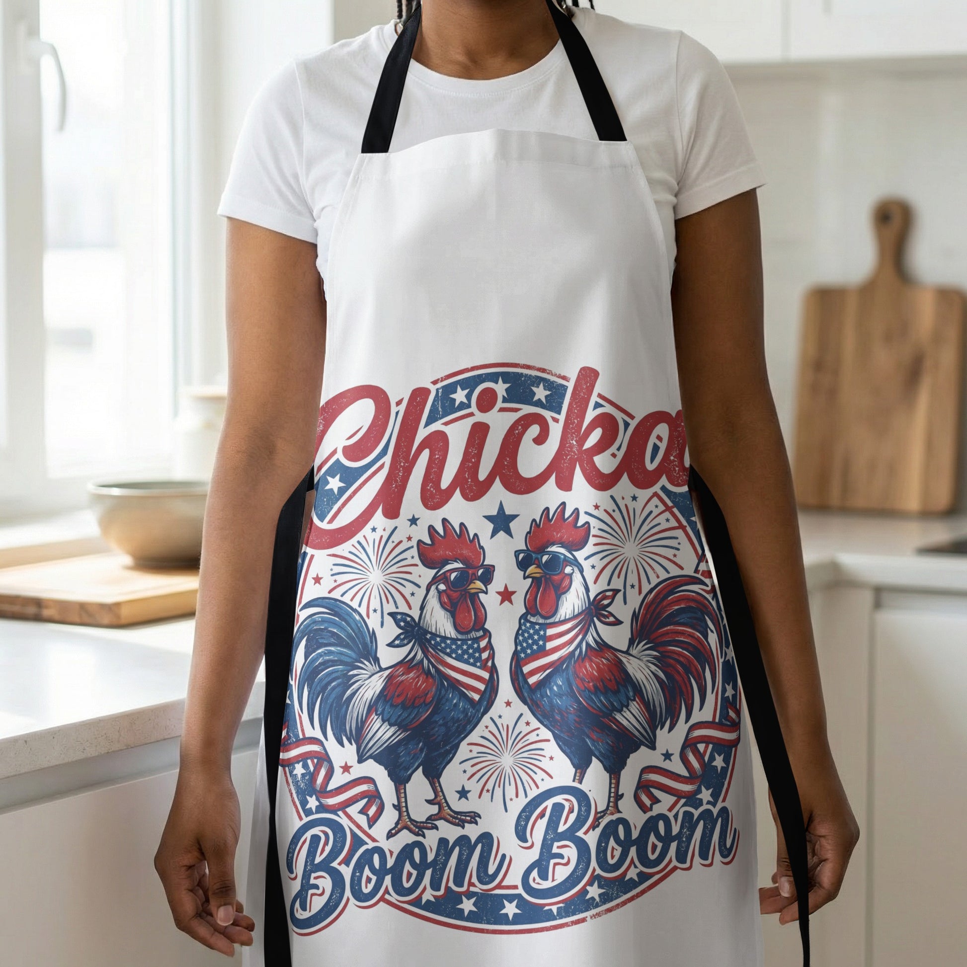 White apron with roosters, sunglasses, fireworks, and text "Chicka Boom Boom".