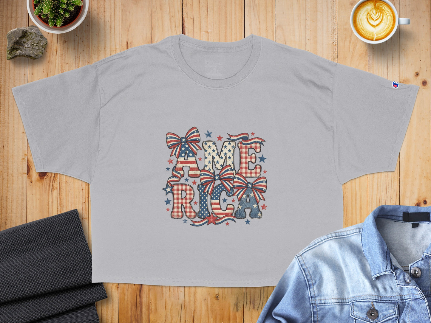 Grey t-shirt with "AMERICA" in distressed patriotic letters and bows.