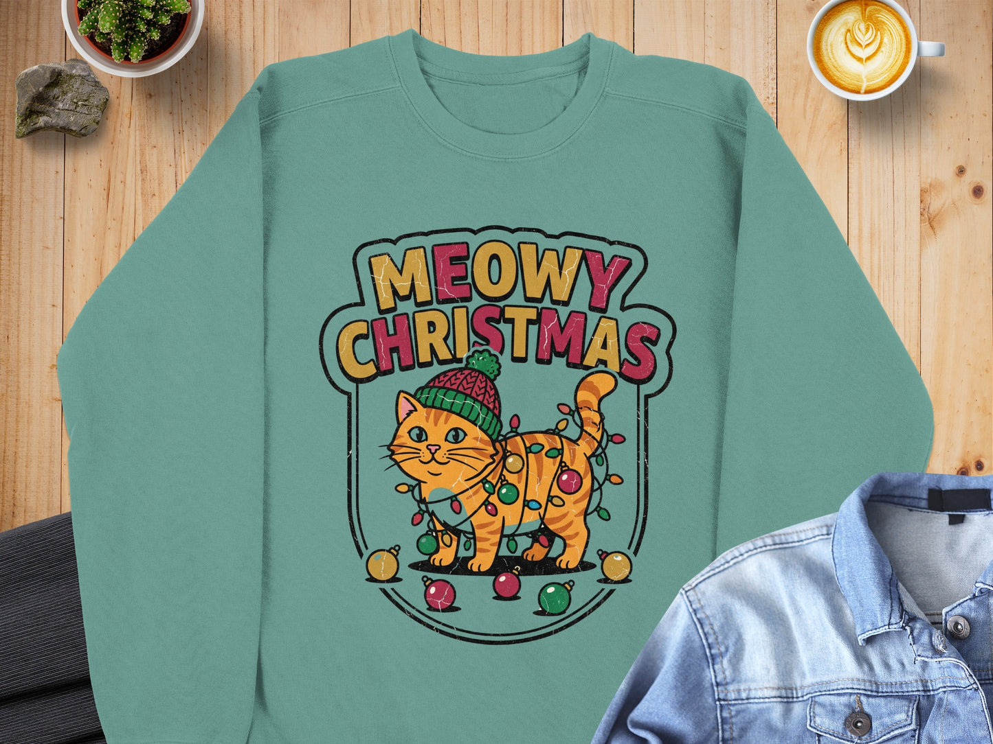 Green sweatshirt with "Meowy Christmas" text and a cartoon cat tangled in lights.