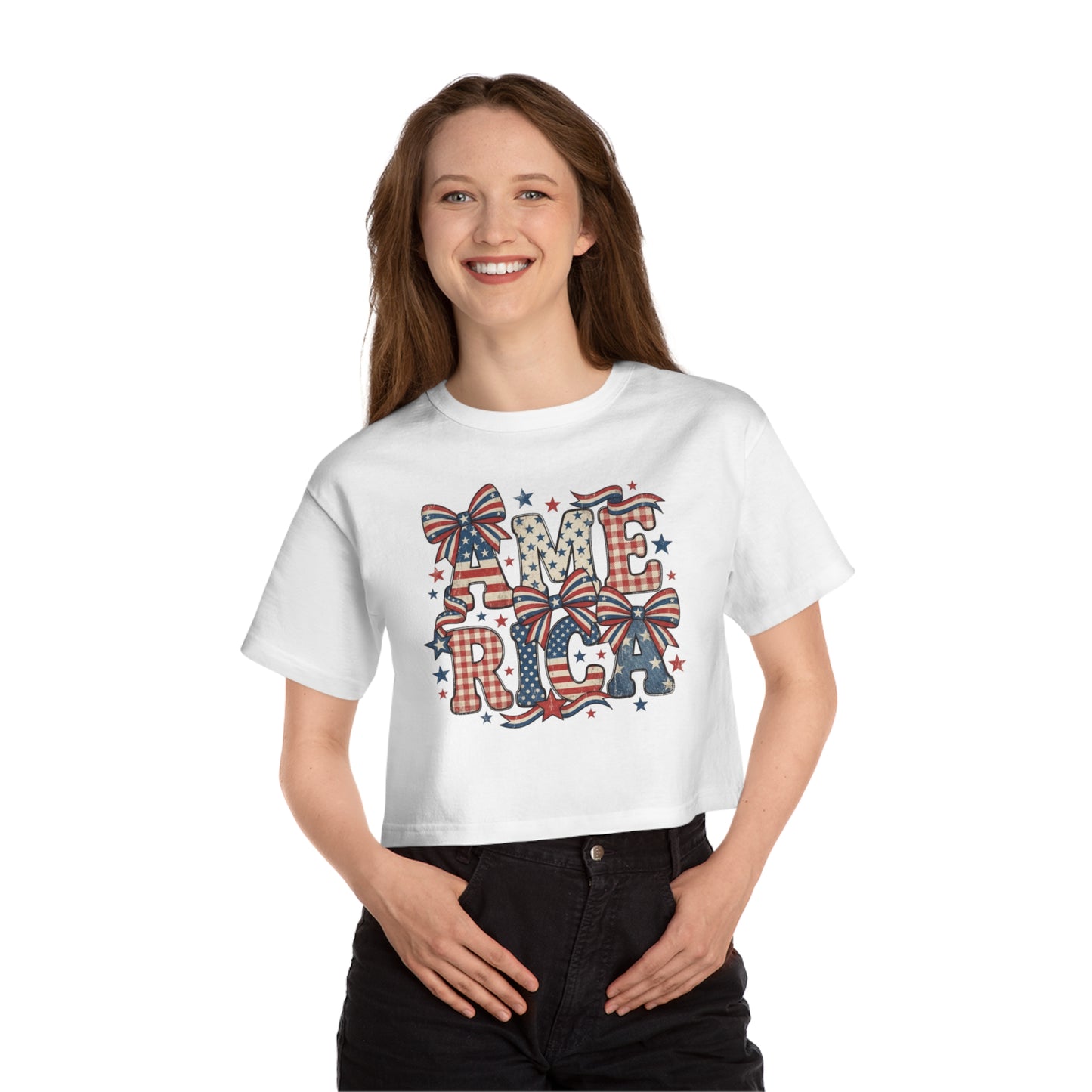 White crop top with distressed "AMERICA" text in patriotic patterns and bows.