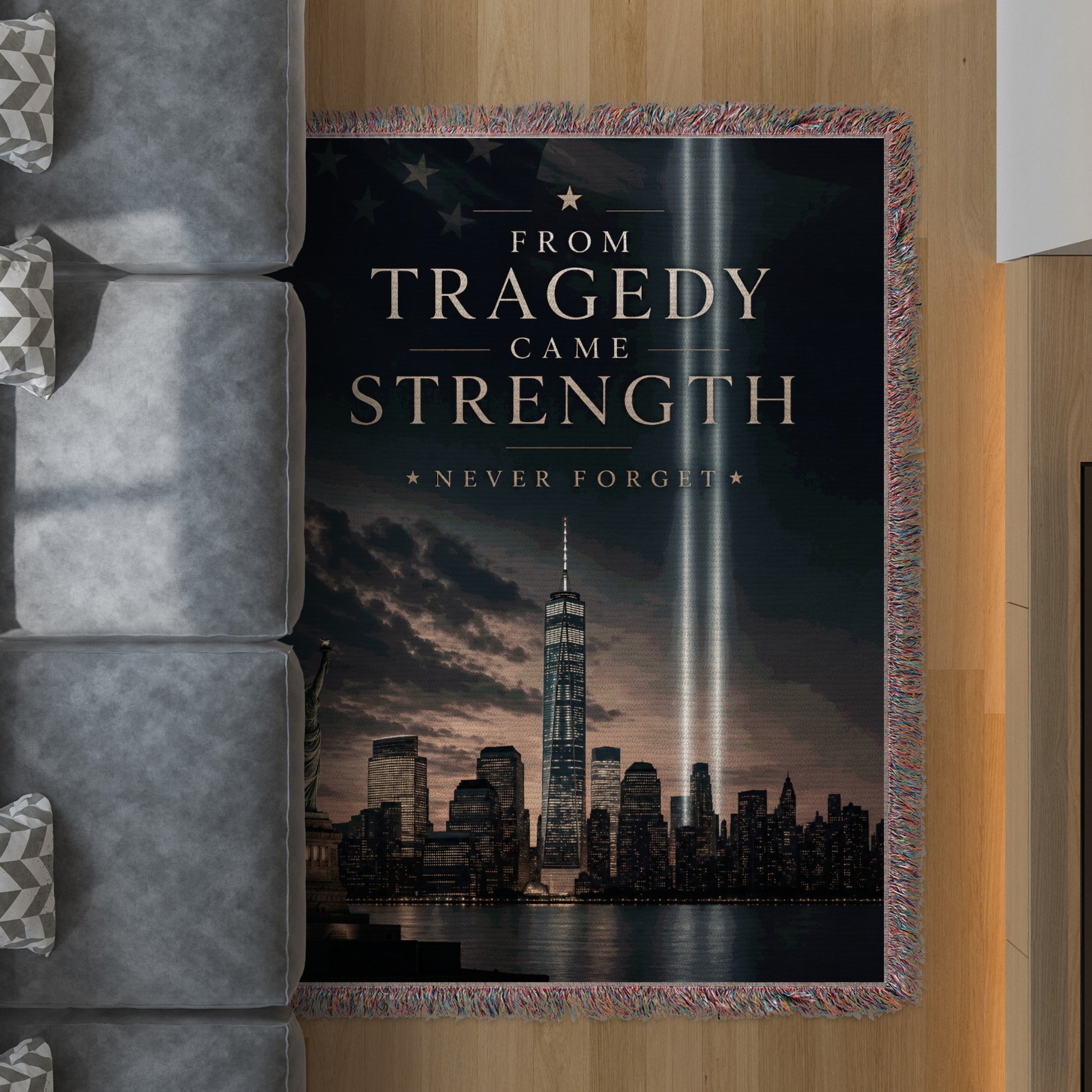 Tribute blanket with "FROM TRAGEDY CAME STRENGTH NEVER FORGET" over NYC skyline.